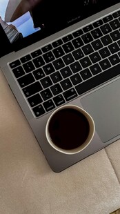 笔记本电脑旁的咖啡杯