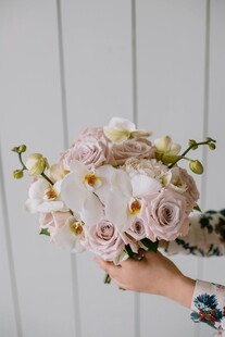 手捧淡粉色浪漫花卉花束