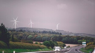 雨中公路旁的风力发电机组