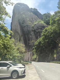公路旁的巍峨山石与汽车