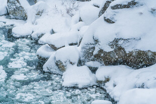冰雪覆盖的岩石与溪流
