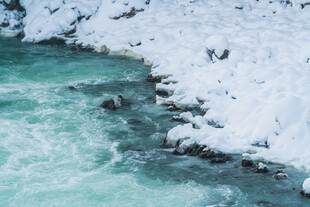 冰雪覆盖的湍急碧绿河流