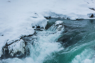 冰雪覆盖下的湍急溪流