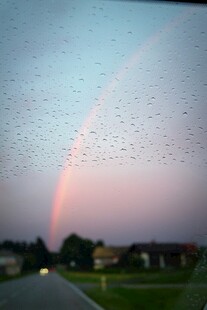 车窗上雨滴后的绚丽彩虹