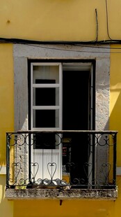 黄色建筑上的黑色铁艺阳台