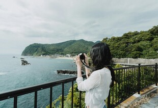 女子凭栏拍摄美丽海景