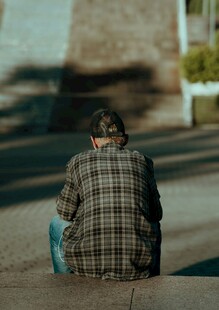 独坐街头的格子衣男子
