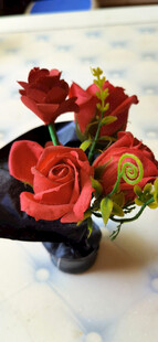 落满灰的仿红玫瑰插花摆放在桌上