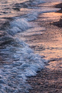 夕阳下的海浪拍打沙滩