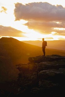 夕阳下的山顶徒步者