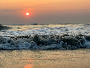 海边日落海浪轻拍沙滩