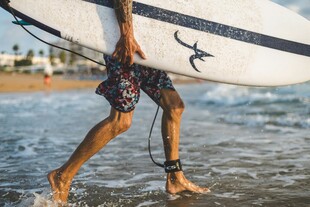 冲浪者踏浪携板前行