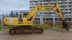 黄色挖掘机停于建筑旁