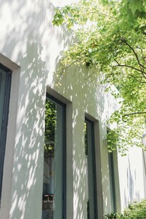 阳光绿树映白墙建筑