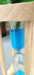 蓝色沙漏置于木质背景中