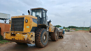 黄色装载机挖掘机停在户外场地