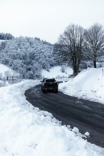 雪天公路上行驶的黑色汽车