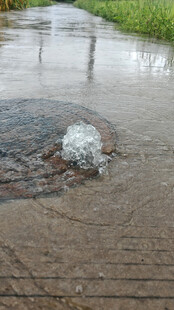 雨天路面下水道井盖溅起的水花