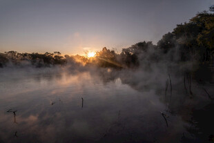 湖畔晨雾中的日出美景