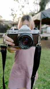 女孩手持相机专注拍照