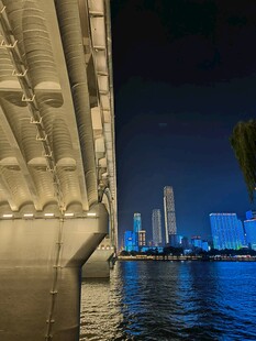 夜晚桥梁下的城市水岸风光