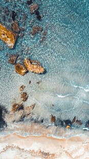 海边礁石海浪轻拍瞬间