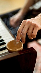 手放钢琴上的咖啡杯