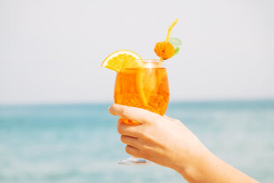 海边手持橙黄鸡尾酒