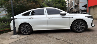 白色轿车停靠在充电桩旁