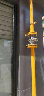 窗边的金属阀门与黄色管道 