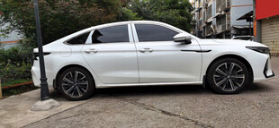 白色轿车停靠在电桩旁