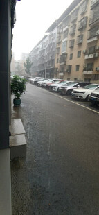 暴雨下街道旁停放整齐的车辆