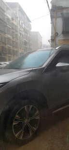 暴雨中黑色汽车停于城市街道