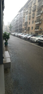 暴雨中城市街道旁停放的车辆