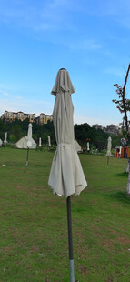 草地上收起的白色遮阳伞