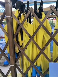 黄色雨衣挂在木质围栏上