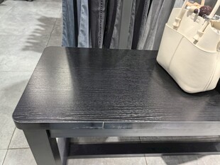 黑色凳子上的米色手提包