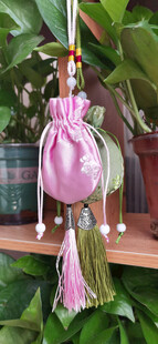 粉色香囊悬挂于绿植旁