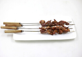 美味烤肉串摆于白盘上