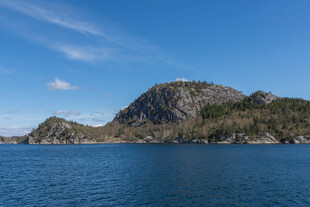 蓝色水域旁的巍峨山峦