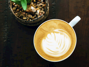 精致拉花咖啡与绿植相伴