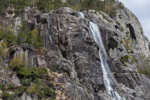 山间瀑布倾泻于嶙峋峭壁