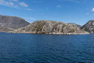 蓝色水域旁的嶙峋山峦