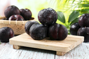 新鲜紫李摆放在木托盘上