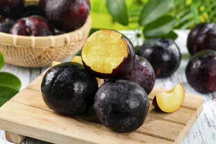 新鲜黑布林摆放在木砧板上