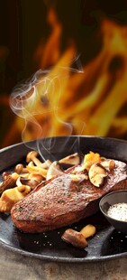 火焰上的美味牛排与蘑菇