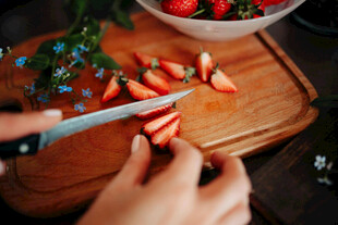 手切草莓于木砧板上