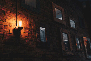 夜晚石墙旁点亮的复古壁灯