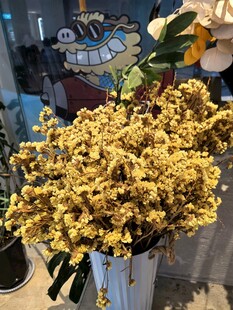 黄色花束插于白色花瓶中