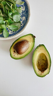 切开的牛油果与绿叶蔬菜